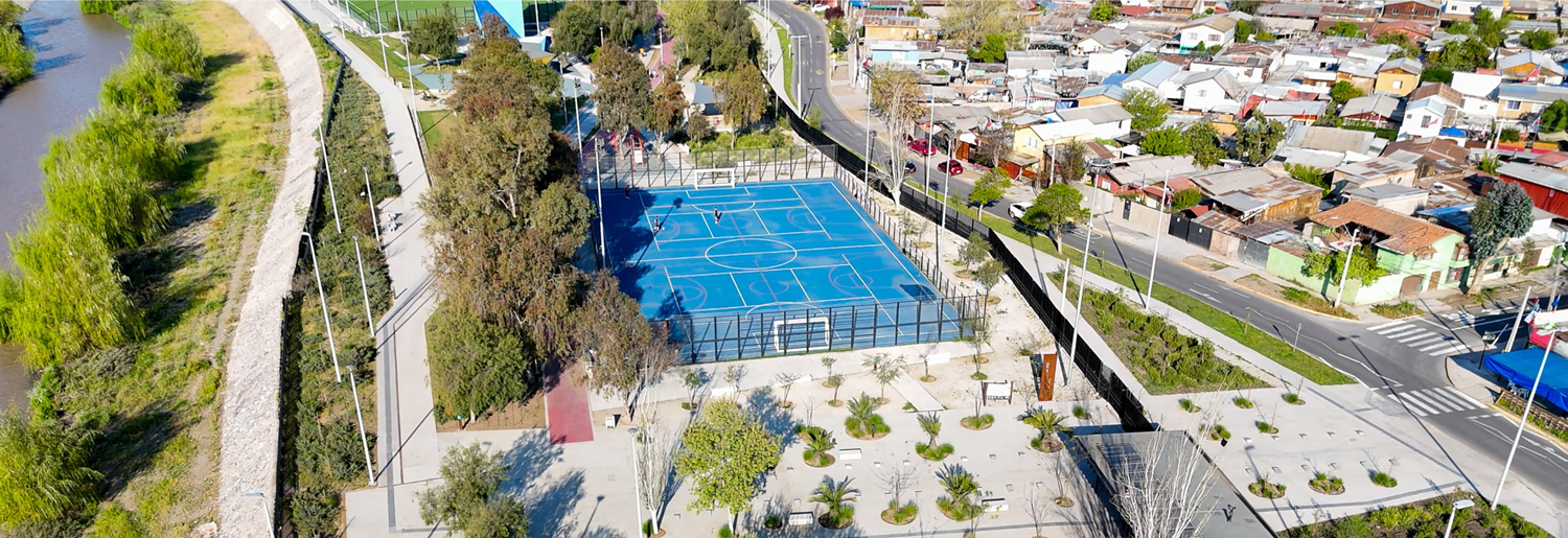 Vista aérea de un barrio con multicancha, áreas verdes y viviendas